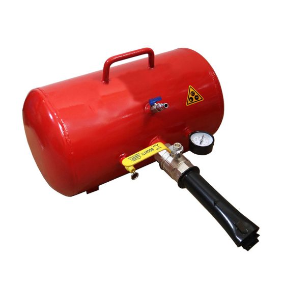 "A red air tank with a handle on top, a pressure gauge, and a nozzle attached. The tank features a warning symbol indicating caution, and the nozzle is connected to a valve with a yellow label that reads 'Warning.' The pressure gauge is used to measure the air pressure inside the tank
