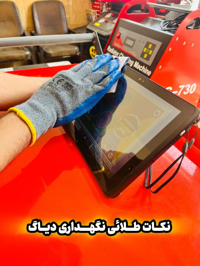 "A person wearing a blue and gray glove cleans a tablet screen with a cloth. The tablet rests on a red surface. In the background, there is a machine labeled 'Rebuilder Charging Machine' with the model number 'C-730.' Two chairs are also visible. The image includes Persian text that translates to 'Golden tips for maintaining diagnostics.